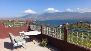 a balcony with a table and chairs and a view of the water at Abla room in Azilal