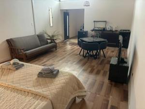 a bedroom with a bed and a couch and a table at Rincón del Agreste in Neuquén