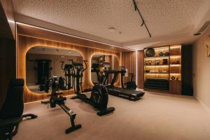 a gym with treadmills and ellipticals in front of a mirror at Hotels 705 O'Porto Hotel in Porto +42 photos