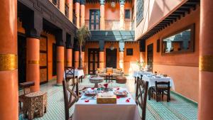 a restaurant with tables and chairs in a building at Riad Sultan Suleiman & Spa in Marrakesh