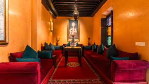 a waiting room with red couches and a table at Riad Sultan Suleiman & Spa in Marrakesh
