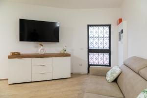 a living room with a couch and a tv on a wall at Sara Home Flo in Florence