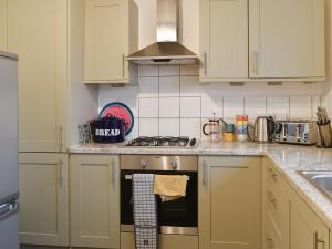 a kitchen with white cabinets and a stove top oven at Tankerton Heights in Whitstable