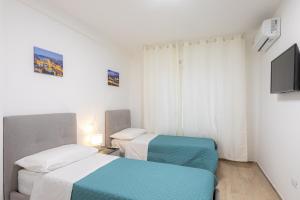 two beds in a small room with a television at Sara Home Flo in Florence