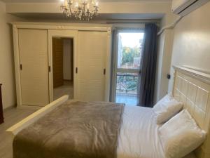 a bedroom with a large bed and a chandelier at Pyramid View Apartment near GEM in Ghaţāţī +4 photos