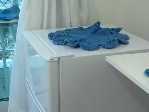 a white shelf with a blue rug on it at Quartos - Cíntia in Fortaleza +39 photos
