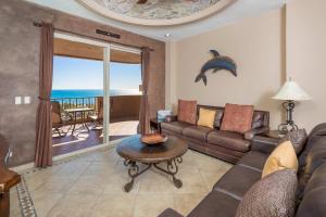 a living room with a couch and a table with a dolphin on the wall at Bella Sirena Beachfront Resort Condo D603 in Puerto Peñasco