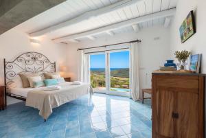 a bedroom with a bed and a large window at Villa Emmeline fronte mare 5 camere 6 bagni infinity pool WiFi per 12 persone in Alghero +87 photos