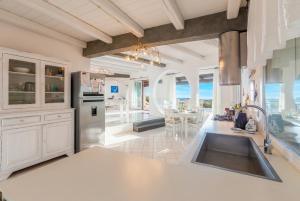 a kitchen with a sink and a counter top at Villa Emmeline fronte mare 5 camere 6 bagni infinity pool WiFi per 12 persone in Alghero
