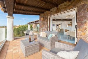 an outdoor patio with couches and a table at Villa Emmeline fronte mare 5 camere 6 bagni infinity pool WiFi per 12 persone in Alghero