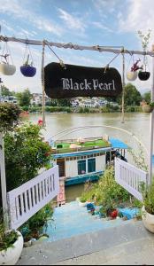 a boat on a river with a sign that reads black pearl at Houseboat Blackpearl in Srinagar