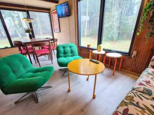 a living room with green chairs and a table at 4 star holiday home in Ry in Ry