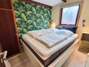 a bedroom with a bed with a green wallpaper at 4 star holiday home in Ry in Ry