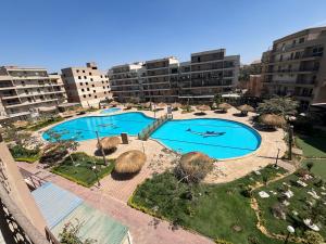 an overhead view of two swimming pools in a city at Pyramid View Apartment near GEM in Ghaţāţī