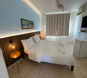 a bedroom with a white bed and a window at Nascimento Suites in Búzios
