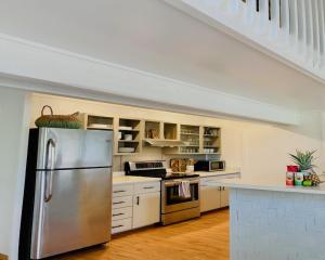 a kitchen with a stainless steel refrigerator and white cabinets at Princeville North Shore Retreat - 1200 SF, Lanai, Loft & Kitchen in Princeville