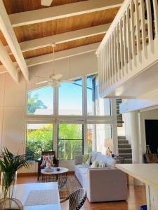 a living room with a couch and a large window at Princeville North Shore Retreat - 1200 SF, Lanai, Loft & Kitchen in Princeville