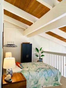 a bedroom with a bed and a table with a lamp at Princeville North Shore Retreat - 1200 SF, Lanai, Loft & Kitchen in Princeville +13 photos