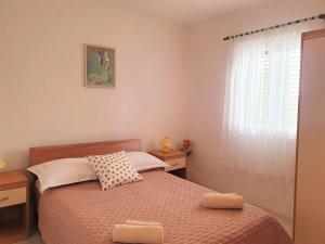 a small bedroom with a bed and a window at Apartment Roko in Podstražje