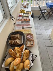 a buffet line with various types of bread and pastries at Nascimento Suites in Búzios +46 photos
