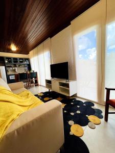 a bedroom with a bed and a tv and a couch at Apartamento Centro de Pirenópolis Goiás in Pirenópolis