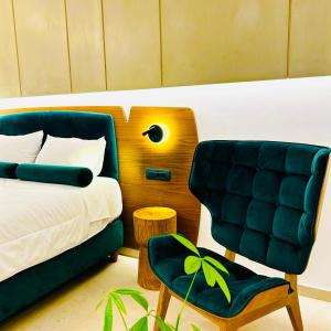 ein Schlafzimmer mit einem Bett und einem grünen Stuhl in der Unterkunft Tramonto Maisonettes & Suites in Parga