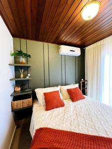 a bedroom with a large bed with red pillows at Apartamento Centro de Pirenópolis Goiás in Pirenópolis