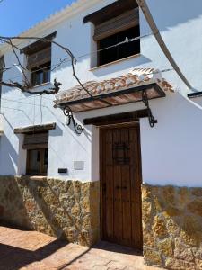 a white building with a wooden door and windows at Cortijo El Nevazo II in Fuentes de Cesna