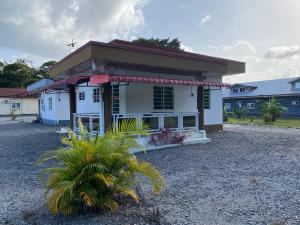 a small white house with a red roof at Augi's Rental in Onverwacht