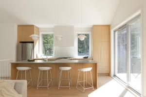 a kitchen with a counter and stools in it at Private Nordic Spa Retreat - Mont-Tremblant in Lac-Superieur