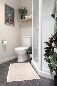 a bathroom with a toilet and a glass shower at Redwoods Retreat Rotorua Private 3BR Home in Rotorua +34 photos