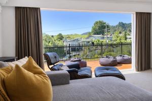 a living room with a couch and a large window at Redwoods Retreat Rotorua Private 3BR Home in Rotorua