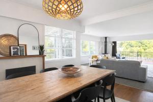 a living room with a wooden table and chairs at Redwoods Retreat Rotorua Private 3BR Home in Rotorua