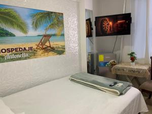 a room with a bed with a picture of a beach at Hospedaje Antonela in Manta