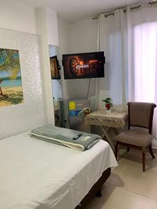 a bedroom with a bed and a tv and a chair at Hospedaje Antonela in Manta +45 photos