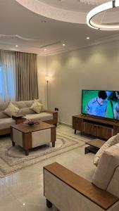 a living room with a couch and a flat screen tv at Rfaa Suites in Medina