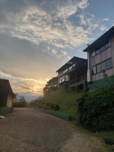 a building on top of a hill next to a road at Pousada Casa da Vista in Visconde De Maua