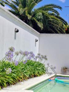 a swimming pool in a garden with purple plants at Casa Colibrí zona Parque Saavedra de La Plata in La Plata