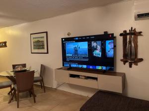 a living room with a large flat screen tv on a wall at Ocean view Studio Marina Lanais in Fajardo