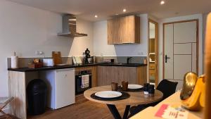 a kitchen with a small table and a kitchen with a stove at L'été sans fin in Bellac