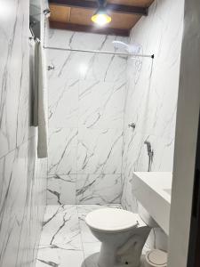 a white bathroom with a toilet and a sink at Apt estiloso 03 in Paragominas +6 photos