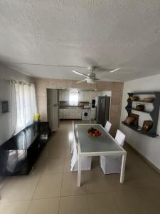 a kitchen and dining room with a table and chairs at Mawoon House in Friar's Bay