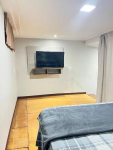 a bedroom with a flat screen tv on a wall at Apt estiloso 03 in Paragominas