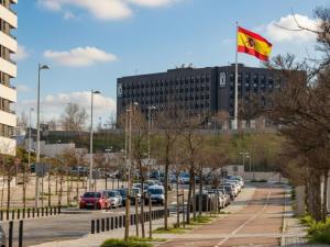 a parking lot with a flag in front of a building at Hotel101 - Madrid in Madrid