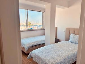 a bedroom with two beds and a window at Guest House Vasco da Gama in Lagos