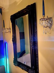 a mirror hanging on a wall with a chandelier at SuiteArtate in Patra +9 photos