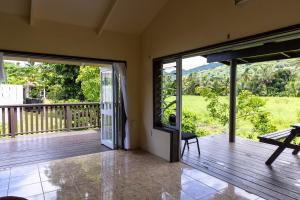 an open porch with sliding glass doors to a deck at Hidden Haven - Group Retreat-Sleeps 7 aircon & free Wifi in Rarotonga