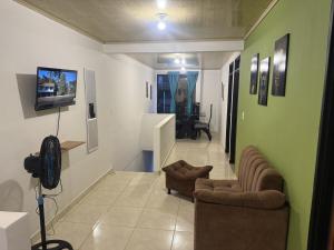 a living room with two couches and a tv on a wall at La Estancia Tolimense in Ibagué