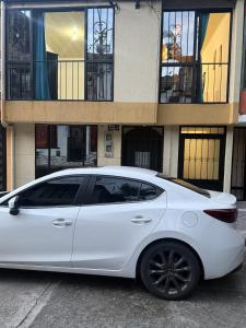 a white car parked in front of a building at La Estancia Tolimense in Ibagué