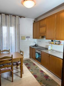 a kitchen with wooden cabinets and a table and a dining room at Altobello Venice Apartment in Mestre +22 photos